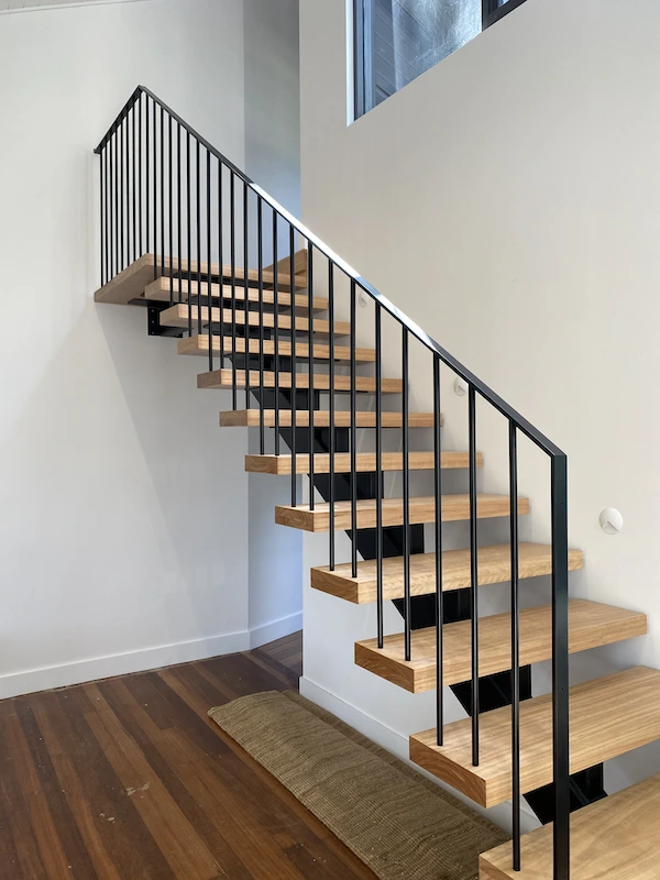 Modern architectural steel staircase with timber treads and black steel balustrade featuring vertical rails - precision residential metalwork by A&E Metal Craft Eastern Suburbs Sydney