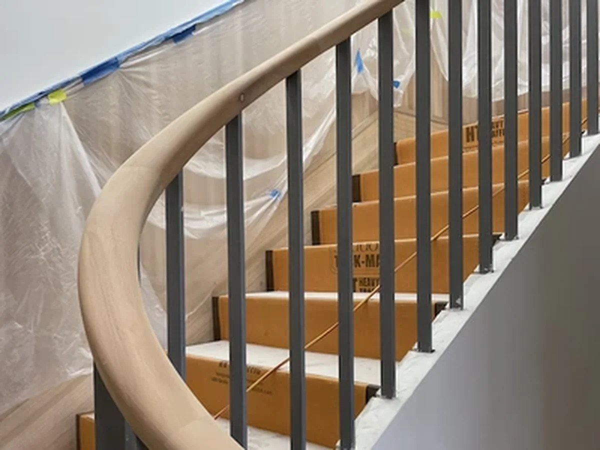 Curved steel stair balustrade with timber handrail featuring modern vertical balusters - residential metalwork North Shore Mosman Sydney by A&E Metal Craft