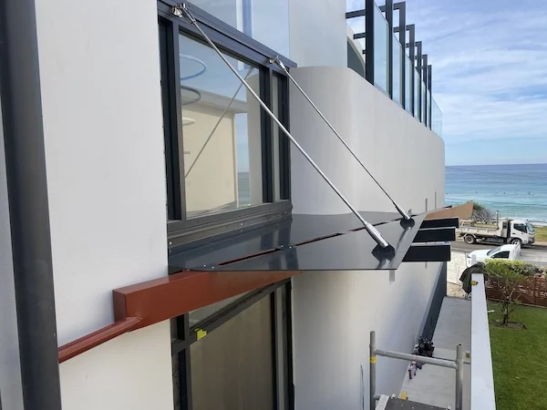 Northern Beaches Curl Curl custom steel awning with hydraulic operation for beachside property - precision architectural metalwork by A&E Metal Craft featuring ocean views and modern engineering